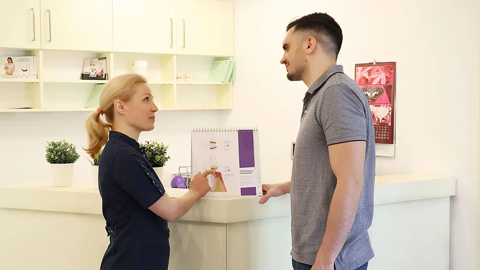 Stomatološkinja pacijentu objašnjava terapiju uz pomoć ilustracija